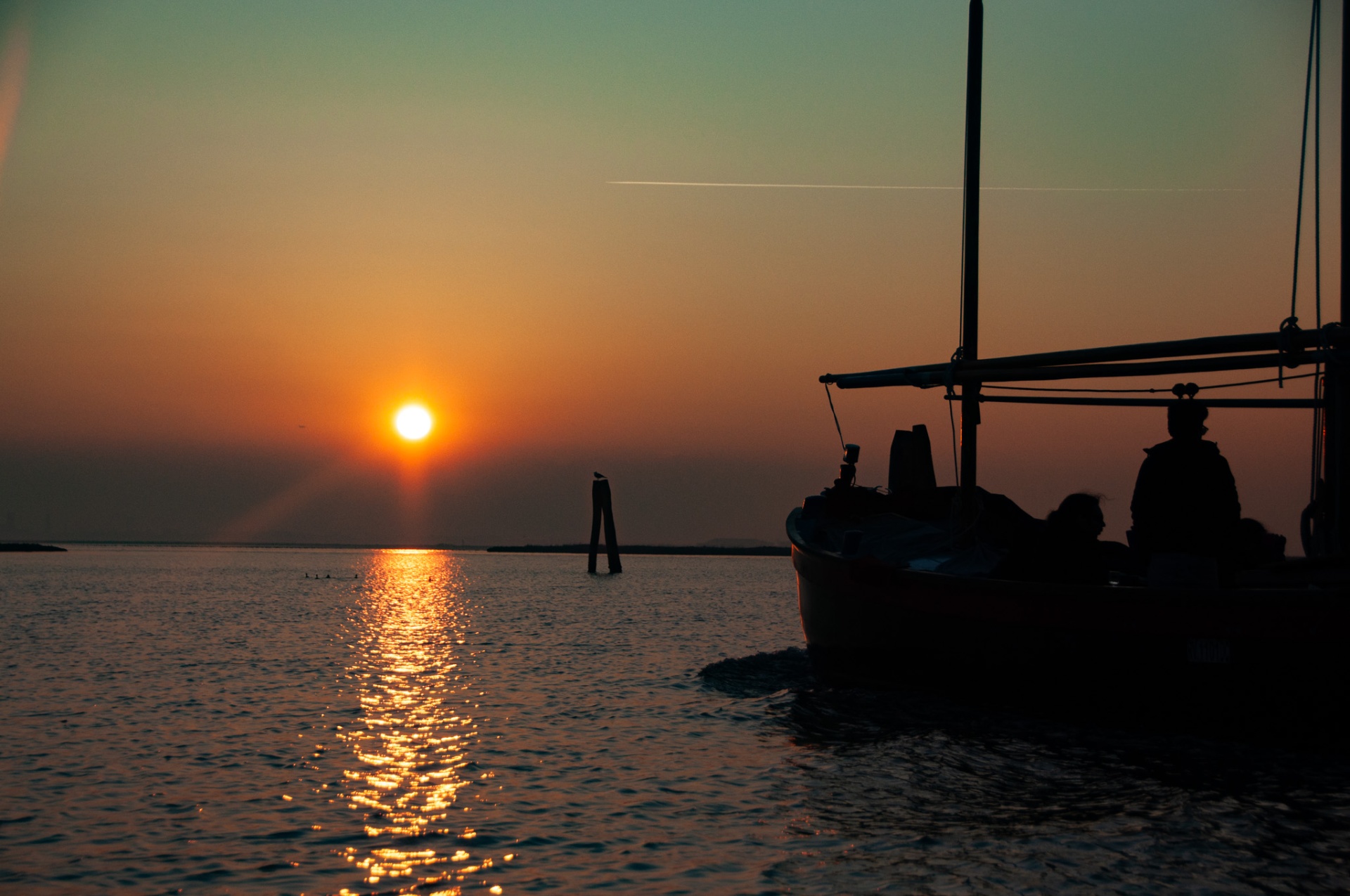 Silhouette of guests aboard a Bragosso at Venetian sunset